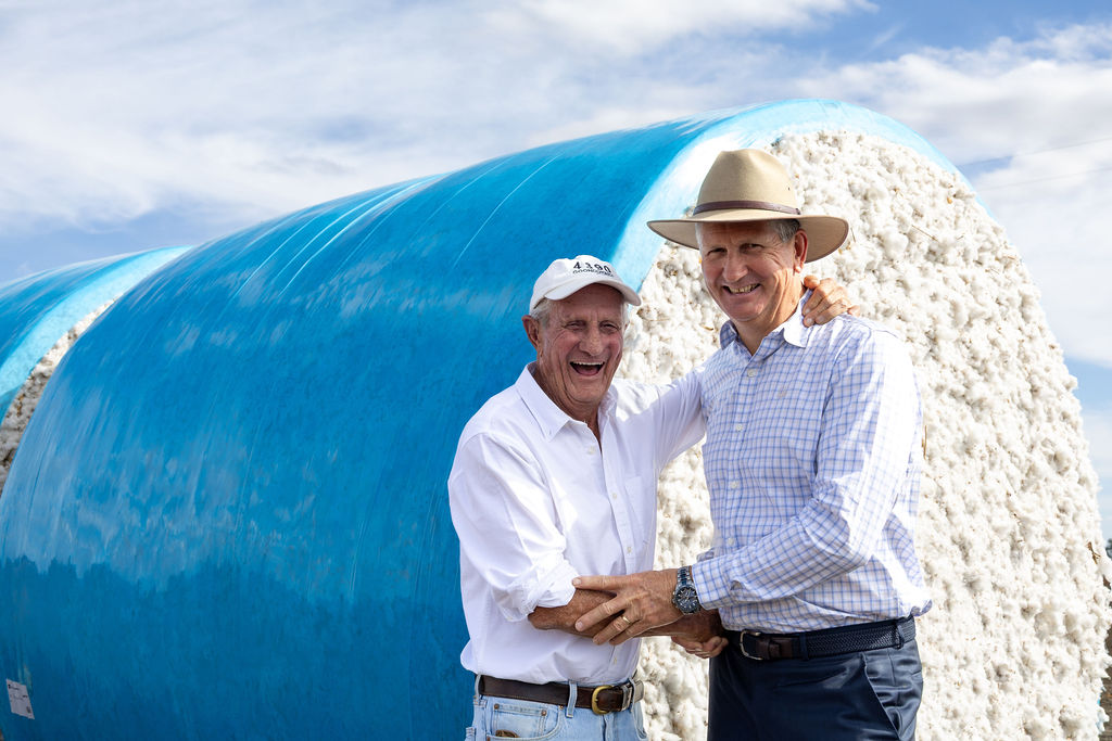 Cotton growers beside harvested cotton